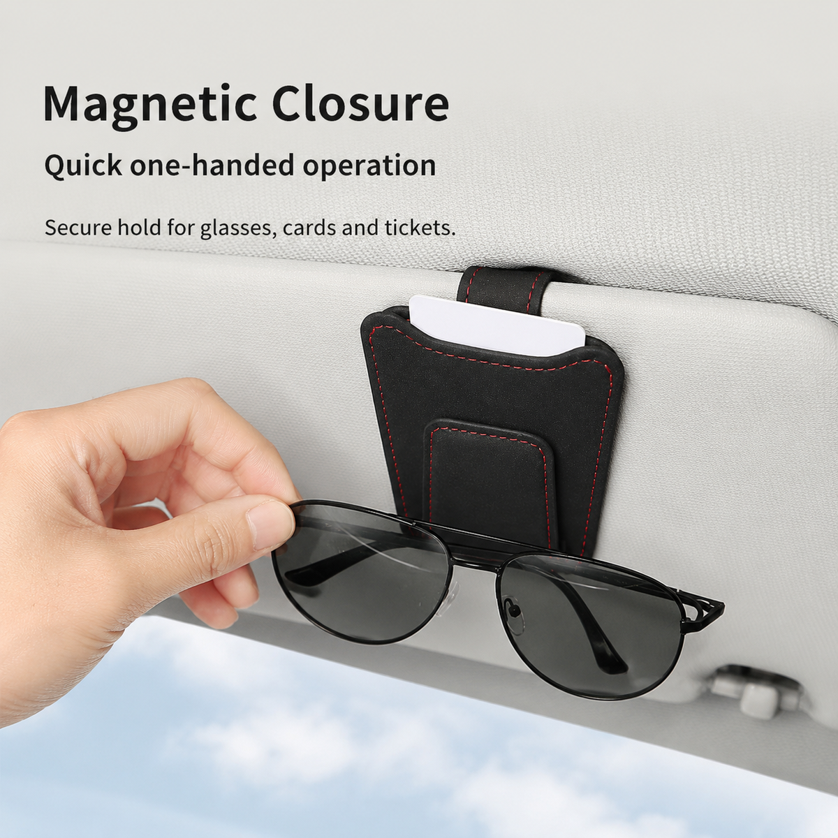 Hand removing sunglasses from a car sun visor holder while the vehicle is parked