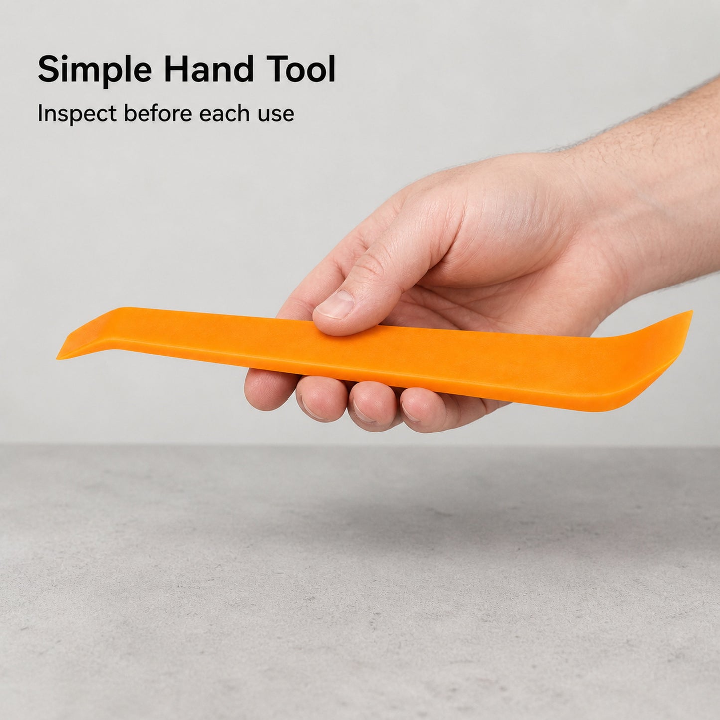 Single orange interior trim tool held for inspection